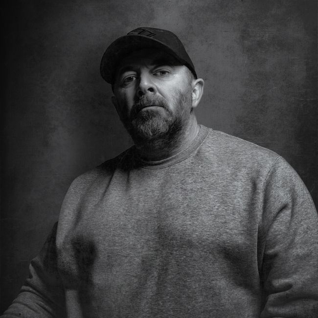 Portrait sombre et contrasté d'un coach sportif masculin en salle de musculation
