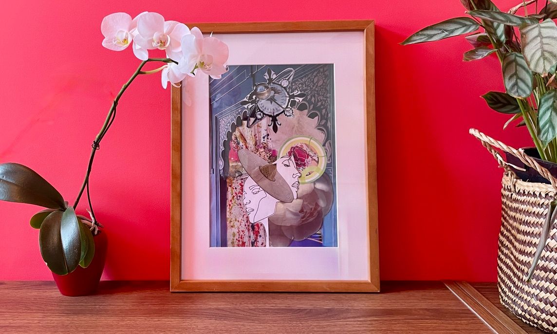 Une muse en collage encadrée en bois et passe-partout blanc, posée contre un mur rose près d'une orchidée